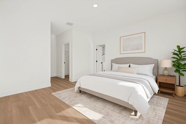 bedroom with light wood-style floors, baseboards, and recessed lighting