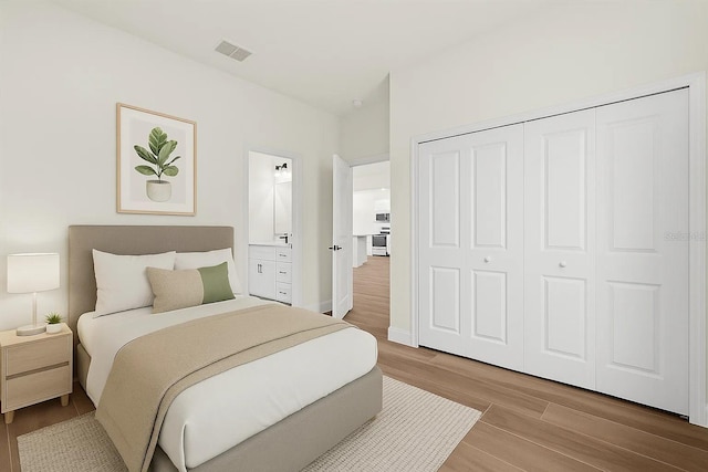 bedroom featuring wood finished floors, a closet, and baseboards