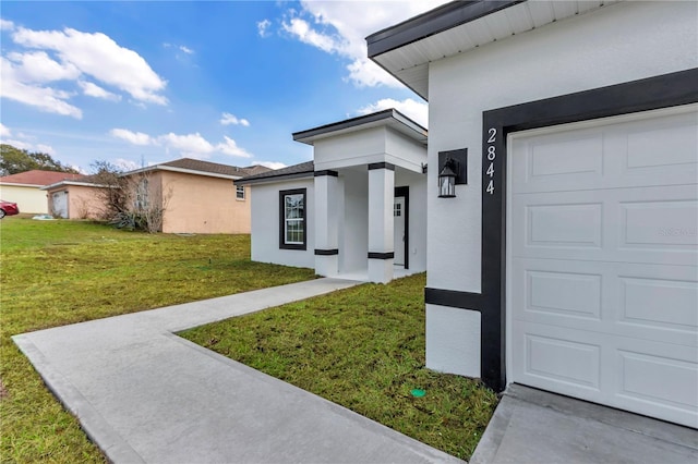 property entrance featuring a yard and a garage