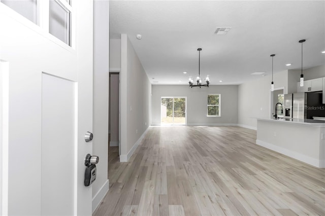2844 SW 162nd Street Rd, Ocala, FL 34473 - unfurnished living room featuring a notable chandelier, sink, and light wood-type flooring