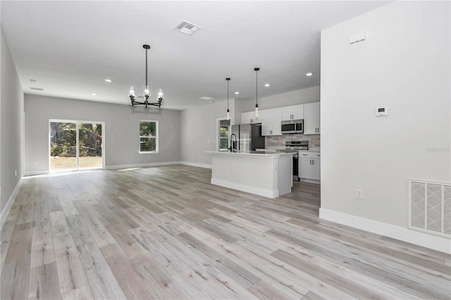 2844 SW 162nd Street Rd, Ocala, FL 34473 - kitchen featuring white cabinetry, hanging light fixtures, light hardwood / wood-style flooring, appliances with stainless steel finishes, and an island with sink