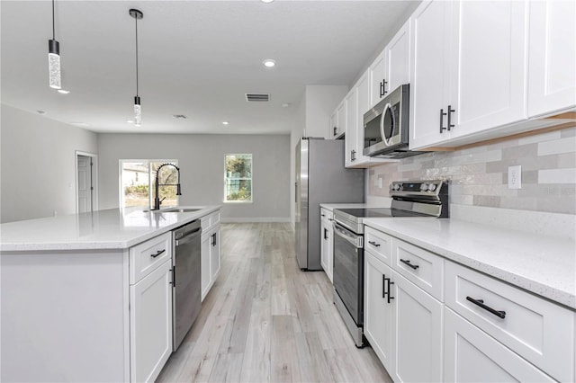 2844 SW 162nd Street Rd, Ocala, FL 34473 - kitchen with sink, hanging light fixtures, stainless steel appliances, white cabinets, and a center island with sink