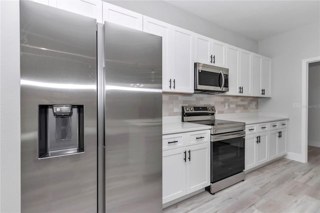 2844 SW 162nd Street Rd, Ocala, FL 34473 - kitchen with white cabinetry, decorative backsplash, stainless steel appliances, and light hardwood / wood-style floors