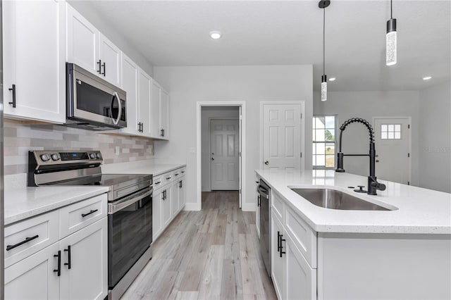 2844 SW 162nd Street Rd, Ocala, FL 34473 - kitchen with pendant lighting, an island with sink, sink, white cabinets, and stainless steel appliances