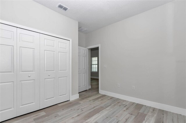 2844 SW 162nd Street Rd, Ocala, FL 34473 - unfurnished bedroom featuring a closet, a textured ceiling, and light hardwood / wood-style flooring