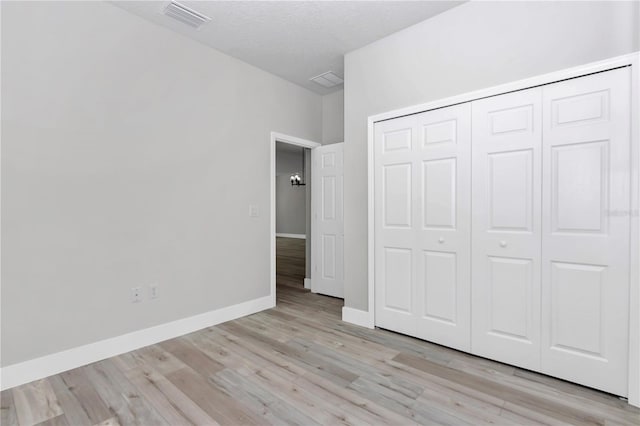2844 SW 162nd Street Rd, Ocala, FL 34473 - unfurnished bedroom with a textured ceiling, a closet, and light wood-type flooring