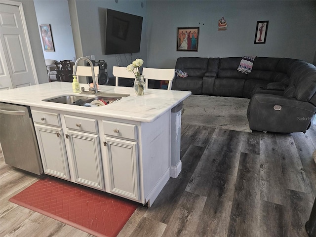 kitchen with sink, white cabinetry, dark hardwood / wood-style flooring, dishwasher, and an island with sink