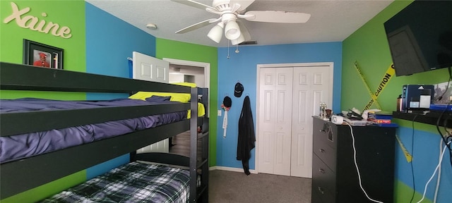 bedroom with ceiling fan, a closet, carpet flooring, and a textured ceiling