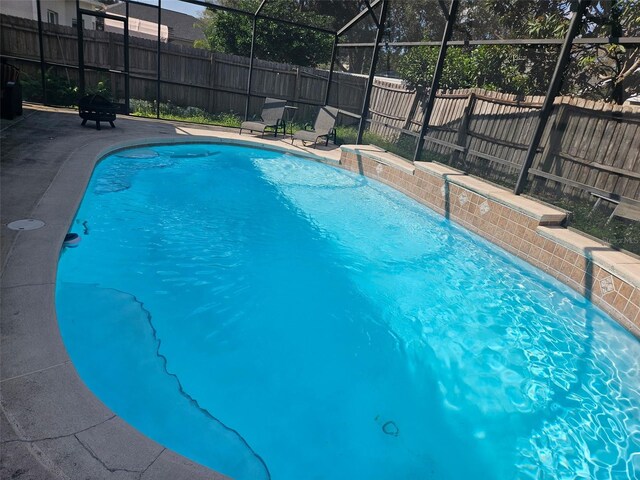 view of swimming pool featuring a lanai and pool water feature