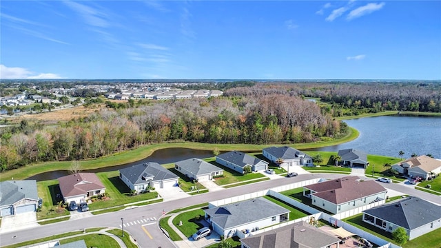 birds eye view of property featuring a wooded view, a water view, and a residential view