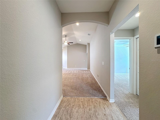 hall featuring arched walkways and a textured wall