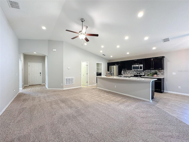 kitchen with arched walkways, visible vents, dark cabinets, and stainless steel appliances