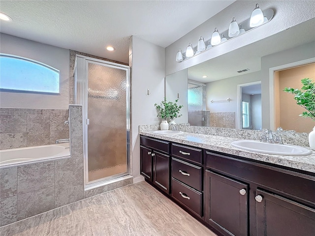 bathroom featuring a sink, visible vents, double vanity, and a shower stall