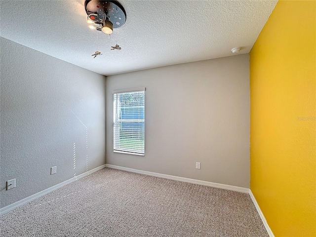 unfurnished room with baseboards, a textured ceiling, carpet flooring, and a textured wall