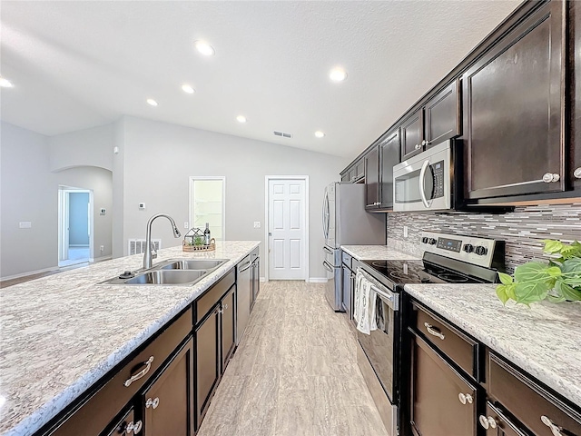 kitchen featuring visible vents, a sink, vaulted ceiling, dark brown cabinets, and appliances with stainless steel finishes