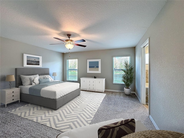 carpeted bedroom featuring baseboards, a textured ceiling, and ceiling fan