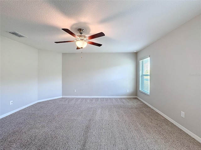 empty room featuring a ceiling fan, baseboards, visible vents, and carpet floors