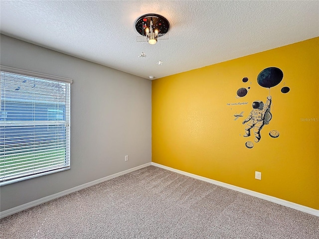 empty room featuring carpet flooring, baseboards, and a textured ceiling