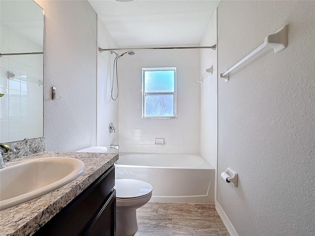 bathroom with toilet, wood finished floors, shower / bath combination, vanity, and a textured wall