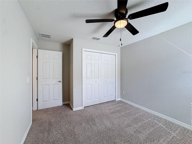 unfurnished bedroom with carpet, visible vents, and baseboards