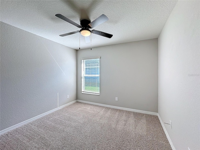 carpeted empty room featuring baseboards, a textured ceiling, a ceiling fan, and a textured wall