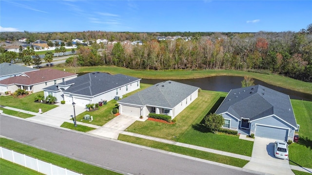 bird's eye view featuring a wooded view and a water view