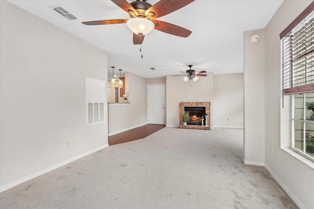 unfurnished living room with dark colored carpet, a brick fireplace, visible vents, and baseboards