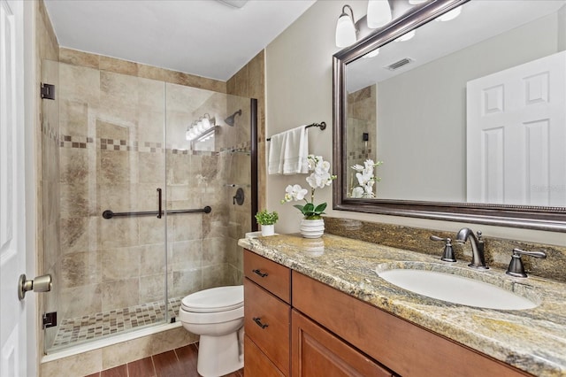 full bathroom featuring toilet, a shower stall, visible vents, and vanity