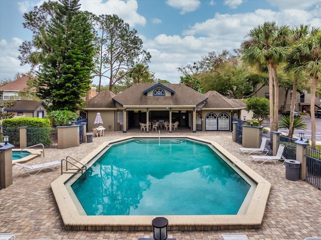 pool with a patio area and fence