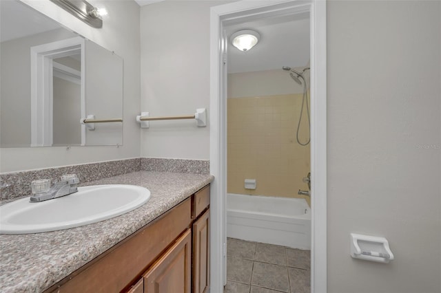 bathroom featuring tiled shower / bath, vanity, and tile patterned flooring