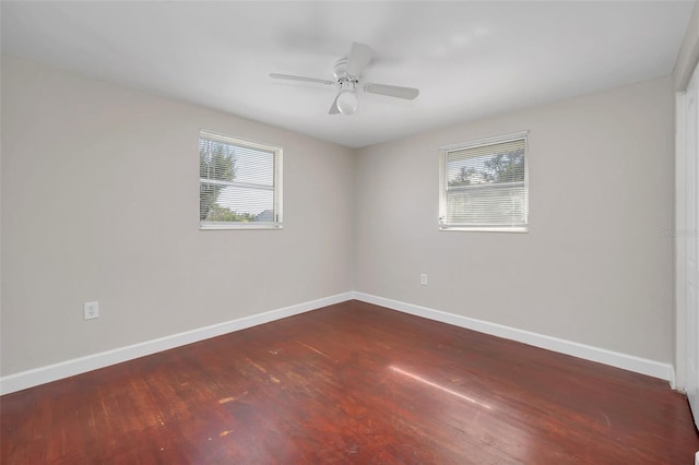 unfurnished room with dark hardwood / wood-style flooring, a wealth of natural light, and ceiling fan