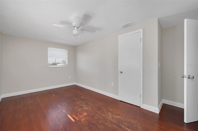 empty room featuring ceiling fan and dark hardwood / wood-style flooring