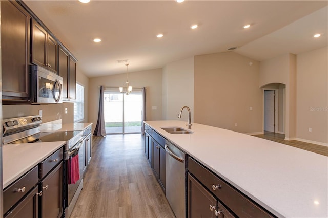 kitchen featuring sink, decorative light fixtures, vaulted ceiling, and stainless steel appliances