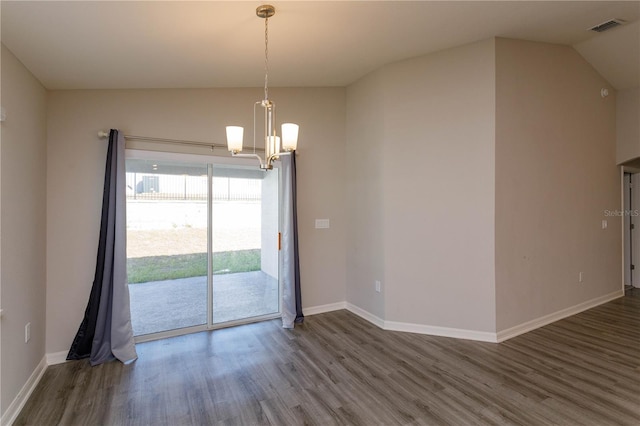 unfurnished room featuring dark hardwood / wood-style flooring, vaulted ceiling, and a chandelier