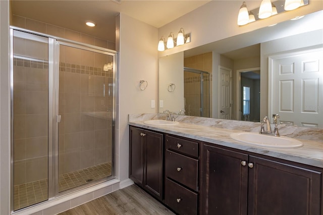 bathroom featuring vanity, an enclosed shower, and wood-type flooring