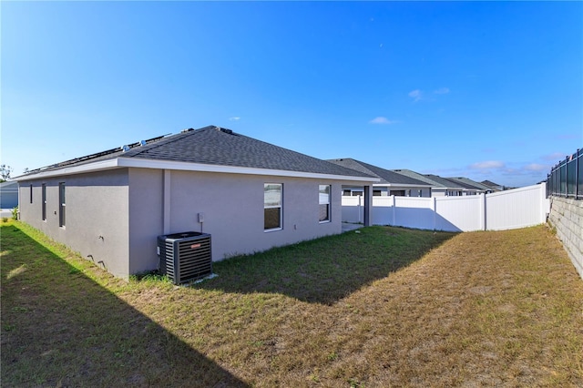 view of property exterior with central AC and a lawn