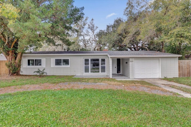 ranch-style house featuring a garage and a front lawn