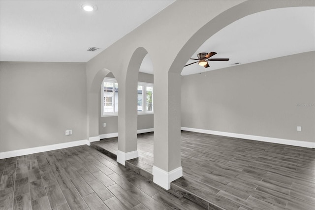 unfurnished living room featuring ceiling fan and dark hardwood / wood-style flooring