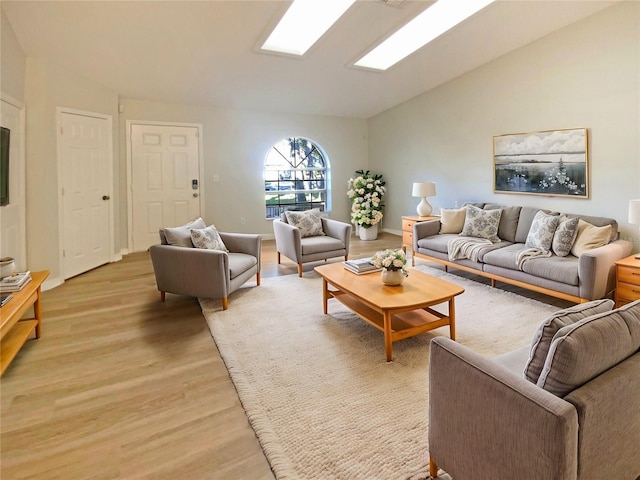 living room featuring lofted ceiling and light hardwood / wood-style floors