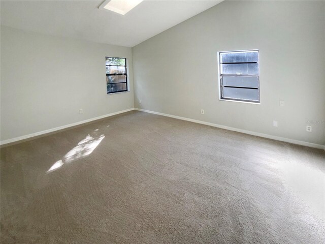 carpeted empty room with lofted ceiling