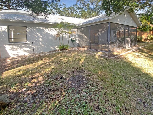 rear view of house with a yard and a sunroom