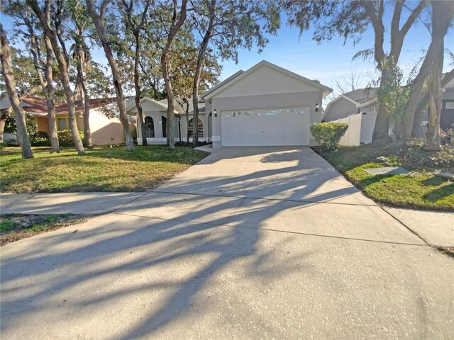 ranch-style home with a garage and a front lawn