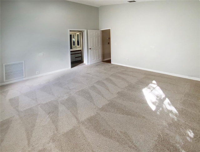 spare room featuring a high ceiling and carpet