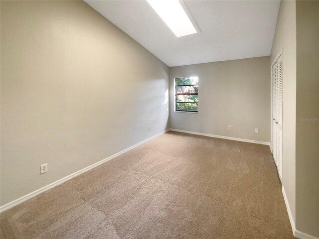 carpeted spare room with lofted ceiling