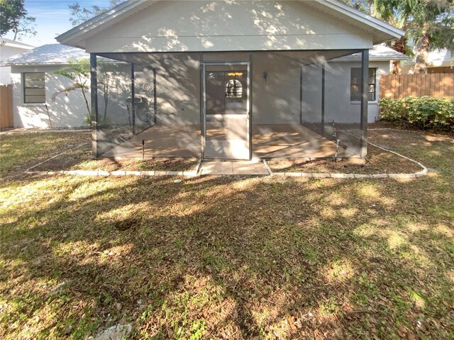 back of property featuring a yard and a sunroom