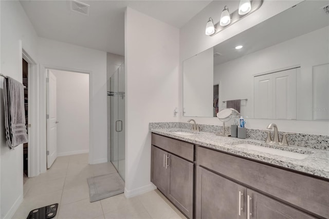 bathroom featuring tile patterned flooring, vanity, and a shower with door