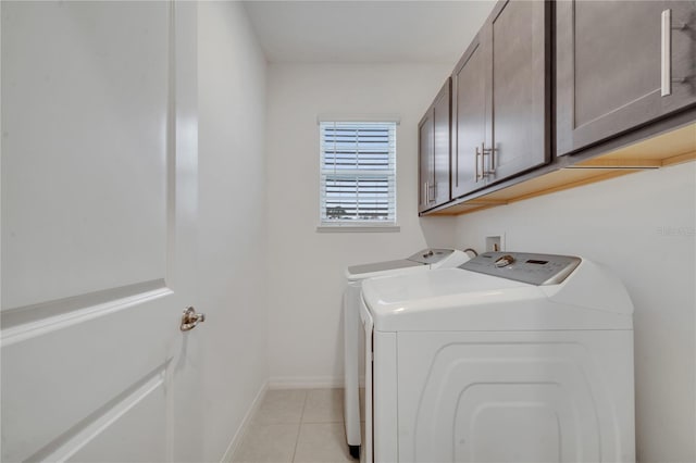 laundry room featuring light tile patterned floors, cabinets, and washing machine and clothes dryer