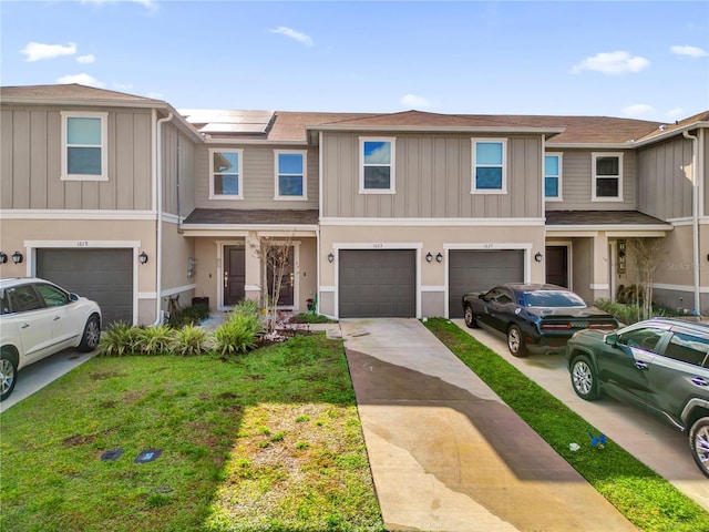 multi unit property featuring a garage, a front yard, and solar panels