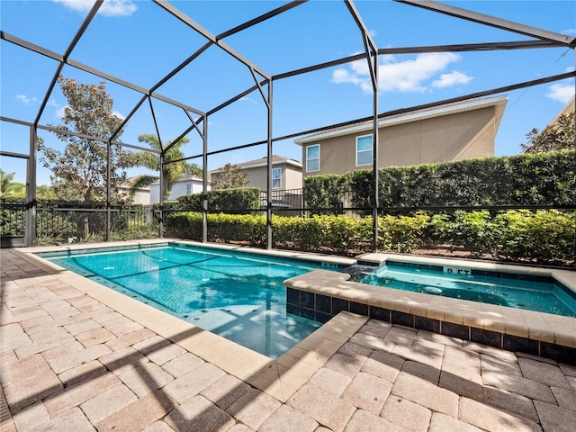 view of swimming pool featuring an in ground hot tub, glass enclosure, and a patio