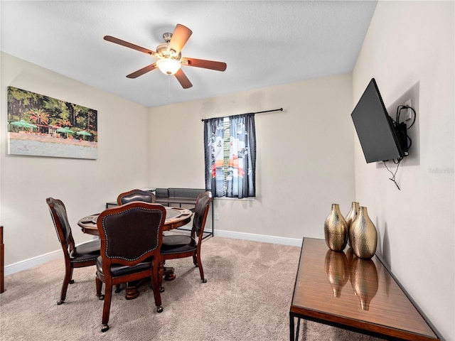 carpeted dining room featuring ceiling fan